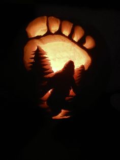 a pumpkin carved to look like a hand with a wolf on it's thumb