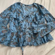 Blouse Brand: Shein Size: Small Color: Blue With Gold/Multi Color Print Details: Size Small Bell Sleeves Self Tie In Front Nwot Ruffle Detail On Front I Ship Same/Next Day I Include A Goodie Bag With Every Package Orders Over $50=Bigger Goodie Bag With Order Blue Bohemian Blouse With Ruffle Sleeves, Blue Ruffled Blouse With Butterfly Sleeves, Blue Printed Blouse With 3/4 Sleeves, Blue Bohemian Blouse With 3/4 Sleeves, Package Orders, Blue Paisley Print Button-up Top, Butterfly Print Dress, Tops Blouse, Shein Tops