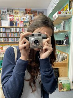 a woman holding up a camera in front of her face