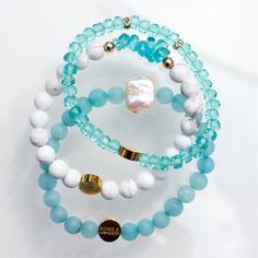 Meet Sylvia, our sea-inspired stack. Featuring soft shades of teal and light blue, it includes three bracelets creating a delicate stack. Each bracelet is also sold separately.This stack honors Sylvia Earle, biologist and leader in ocean science, Sylvia was the first woman to walk the ocean floor. DETAILS Metal: 14K Gold Filled Materials: Howlite, Apatite, Jade, Glass Crystals, Cultured Fresh-water Pearl, Elastic Nylon Size: S|M ~ 6.5", L|XL ~ 7.5". Everyday Stackable Blue Bracelets, Elegant Stackable Beaded Bracelets For Beach, Elegant Turquoise Bracelets For Beach, Elegant Turquoise Aquamarine Beaded Bracelets, Sylvia Earle, Teal And Light Blue, Ocean Science, Ocean Floor, Shades Of Teal