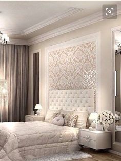 a large white bed sitting in a bedroom next to a tall mirror on the wall