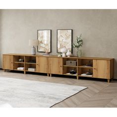 a living room scene with focus on the sideboard and two framed pictures above it