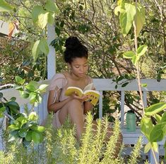 a woman sitting on a bench reading a book