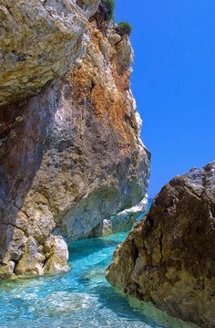 the water is crystal blue and clear in this photo, with rocks on either side