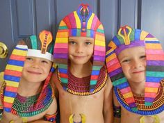 three young boys wearing colorful costumes and headdress