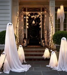 halloween decorations with ghost heads and lights in front of a house