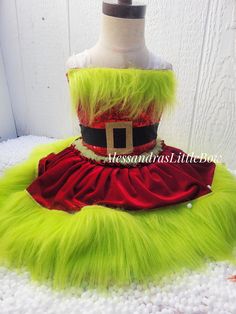 a green and red dress on top of a mannequin's headdress