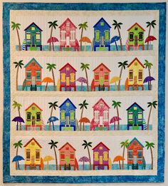 a quilted wall hanging with colorful houses and palm trees