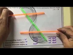 two hands are holding an orange and green object in front of a white sheet with diagrams on it