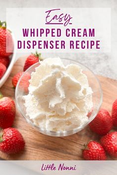 a bowl of whipped cream next to strawberries on a cutting board with the words easy whipped cream dispenser recipe