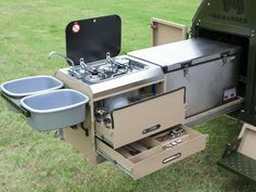 an outdoor stove and sink in the grass