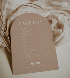 the price list is displayed on top of a white cloth with some dried grass in front of it