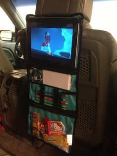 the back seat of a car with a television and snacks on it's shelf