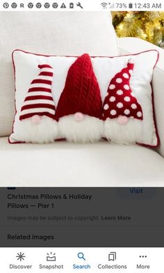 a white couch with two red and white christmas hats on it's back pillows