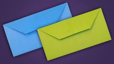 two blue and green envelopes sitting side by side on a purple background, one is folded in half