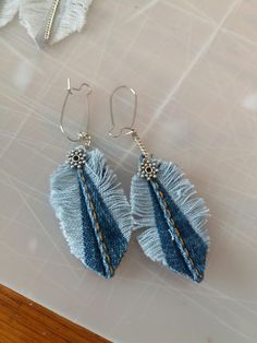 two pairs of blue earrings on a table