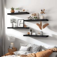 a bedroom with white walls and wooden shelves on the wall, along with various decorative items