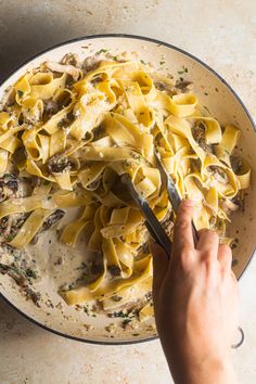 a person is cutting up some food in a bowl