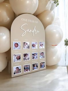 a white photo frame with balloons in the background and one year of san francisco written on it