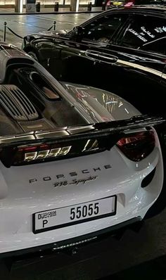 two porsche sports cars parked in a showroom with their hoods open and there is no image on it