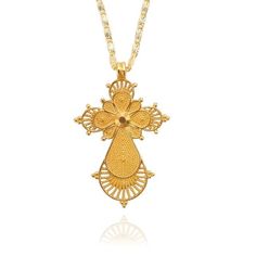 Laid out in the fabulous golden finish, this Ethiopian-style cross piece features a Habesha designed cross. The simple layout is made extraordinary by the minute knotted lines that are laid out to form the interior of the pendant. the original outline is set in a multi-layered pattern where the inner shapes are set in a heavier solid interior and the outer symbol is filled with a more linear design. Tiny golden microbeads are spread along the border to add style to this Innovato Design piece.  Product Highlights    Bright Gold Finish  Made from durable Zinc Alloy  Chain Necklace Included Gold Filigree Cross Pendant Necklace, Gold Cross Jewelry With Large Pendant, Gold Filigree Cross Necklace, Gold Cross Necklace With Filigree, Gold Intricate Cross Jewelry, Spiritual Gold Cross Necklace, Gold Spiritual Cross Pendant Necklace, Gold Cross Jewelry With Intricate Design, Gold Cross Pendant With Intricate Design