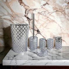 a marble counter top with silver vases and toothbrush holders