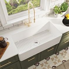 a kitchen sink sitting on top of a counter next to a window with potted plants