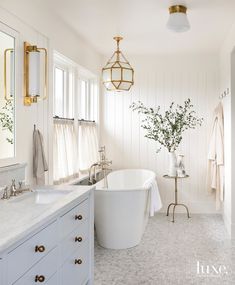 a bathroom with a tub, sink and mirror