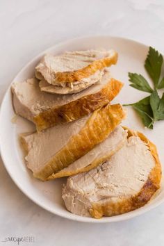 sliced turkey on a white plate with parsley