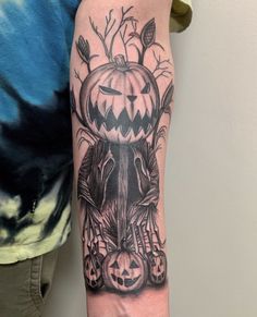 a person with a tattoo on their arm holding up a pumpkin and an elephant head