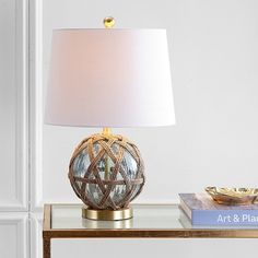 a table with a lamp on top of it and a book sitting next to it