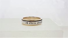 "\"Ani L'Dodi V'Dodi Li BAND ROLLING RING\" This beautiful rolling band ring is made of 925 Sterling Silver and 9 kt gold. ( Marked 925 and 9K) Size: 6, 7, 8, 9, 10,11 Engraved in Hebrew letters: \"Ani L'Dodi V'Dodi Li\" \"I am my beloved's and my beloved is mine,\" - Song of Songs (Shir HaShirim), Chapter 6, verse 3A. Many phrases from The Song of Songs written by King Solomon, have been used throughout weddings for centuries. When you read the entire poem from where this phrase comes from, it Songs Written, Song Of Songs, Rolling Ring, Hebrew Letters, King Solomon, Spinning Rings, Jewish Jewelry, Beautiful Love Stories, Etsy Wedding Rings