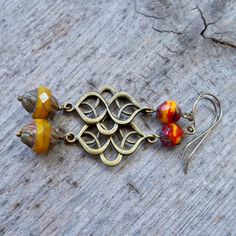 This series has a lot of beautiful orange, yellow, and red Czech glass beads. There are several items in the series that will all mix and match. Be sure to click on the link below. This listing is for these long dangle earrings with beautiful yellow orange beads. The bottom bead is 12 x 10mm with a Picasso finish. The top bead is a mix of glass and each bead is slightly different. Every bead is unique and beautiful. These are offered with antique brass findings and your choice of brass or titani Amber Czech Glass Dangle Earrings, Nickel-free Amber Czech Glass Earrings, Vintage Orange Earrings With Czech Glass, Handmade Amber Earrings In Czech Glass, Vintage Orange Czech Glass Earrings, Brown Earrings With Colorful Beads For Gift, Multicolor Beaded Brass Earrings For Gift, Multicolor Beaded Brass Earrings As Gift, Multicolor Brass Beaded Earrings For Gift