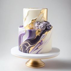 a three tiered cake decorated with purple and gold marbled icing on a white plate