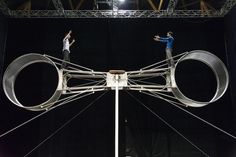 two men standing on top of a giant metal object