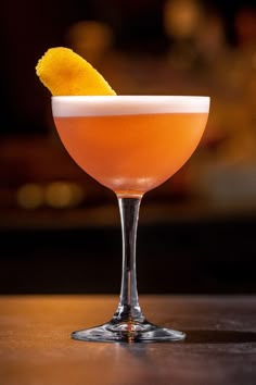 a glass filled with a drink sitting on top of a table