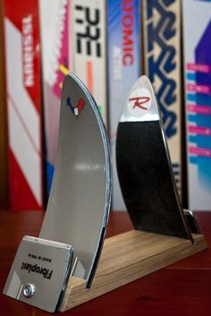 a pair of surfboards sitting on top of a wooden table next to bookshelves