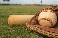 a baseball glove and ball sitting on top of a grass covered field next to a wooden bat