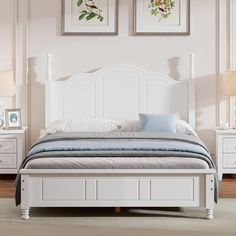 a white bed sitting in a bedroom next to two framed pictures