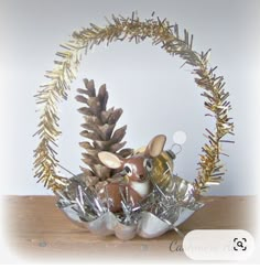 a basket filled with christmas decorations on top of a wooden table next to a pine cone