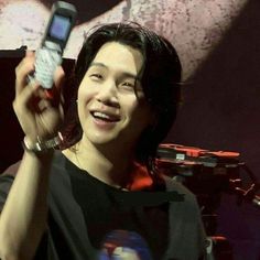 a person holding up a cell phone in front of their face and smiling at the camera