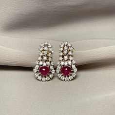 Cabochon Ruby with Diamond Drop Earrings The combination of Cabochon Rubies and Diamonds creates a timeless and versatile piece. A luxurious cabochon ruby, known for its smooth, rounded shape and rich, vibrant color that captures the light beautifully. This pair of chandelier earrings is set in 18K Yellow and White Gold. The elegant drop style offers a graceful movement, making these earrings perfect for formal occasions and everyday wear. For any questions or additional information, please don' Luxury Oval Ruby Earrings, Formal Round Gemstone Bridal Earrings, Luxury Cabochon Earrings For Wedding, Formal Ruby Gemstone Diamond Earrings, Ruby Gemstone Diamond Earrings For Formal Occasions, Elegant Red Diamond Earrings For Formal Occasions, Luxury Ruby Gemstone Earrings, Ruby Earrings With Elegant Design, Elegant Ruby Earrings With 17 Jewels