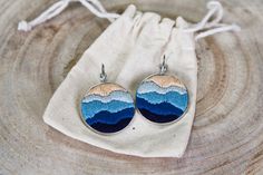 the earrings are made out of wood and have mountains painted on them