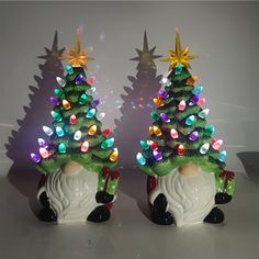 two ceramic christmas trees sitting next to each other