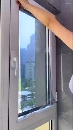 a person is opening the window with their hand