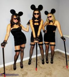 three women dressed up as mickey mouses with canes and hats on their heads