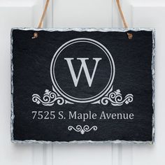 a slate hanging sign with the letter w on it