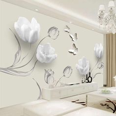 a living room with white furniture and flowers on the wall