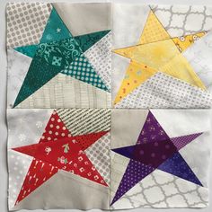 four different colored stars on a white surface