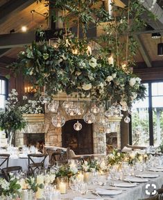 an image of a table setting with candles and greenery on the fireplace mantel